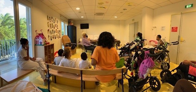 Photo d'enfants malades assis qui écoutent la lecture faite par une bibliothécaire