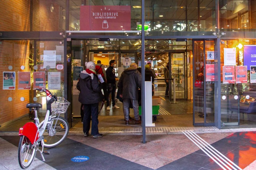 Des usagers passent le portique d'une bibliothèque.