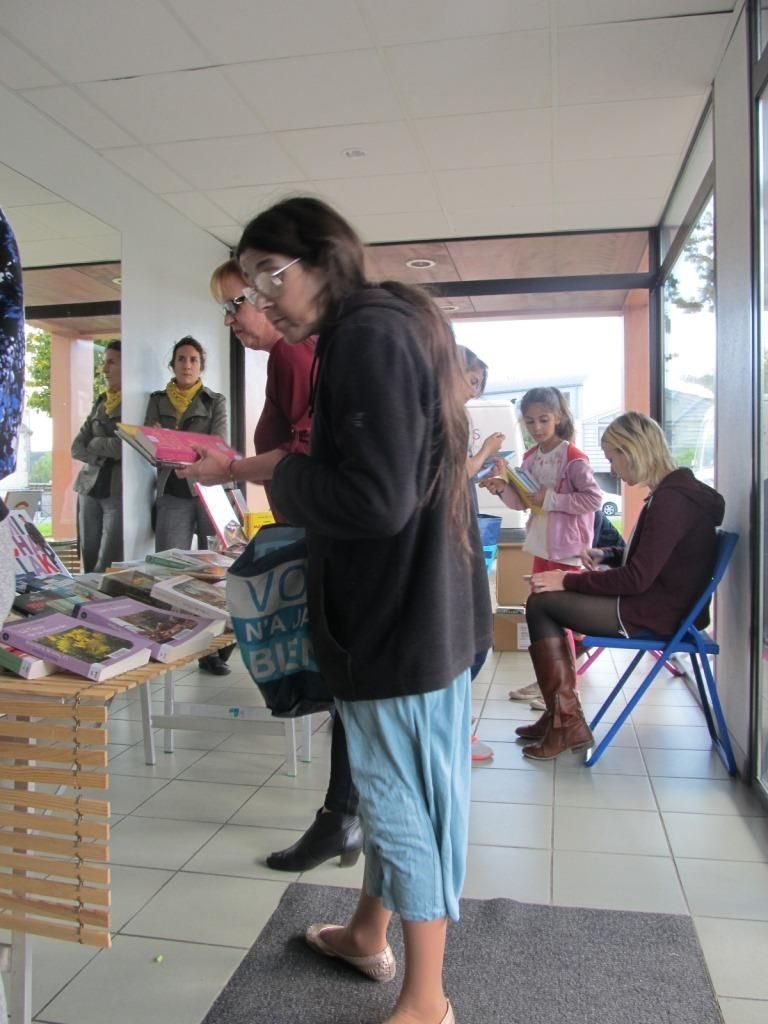 Photographie d'habitants qui empruntent des livres dans un hall d'immeuble