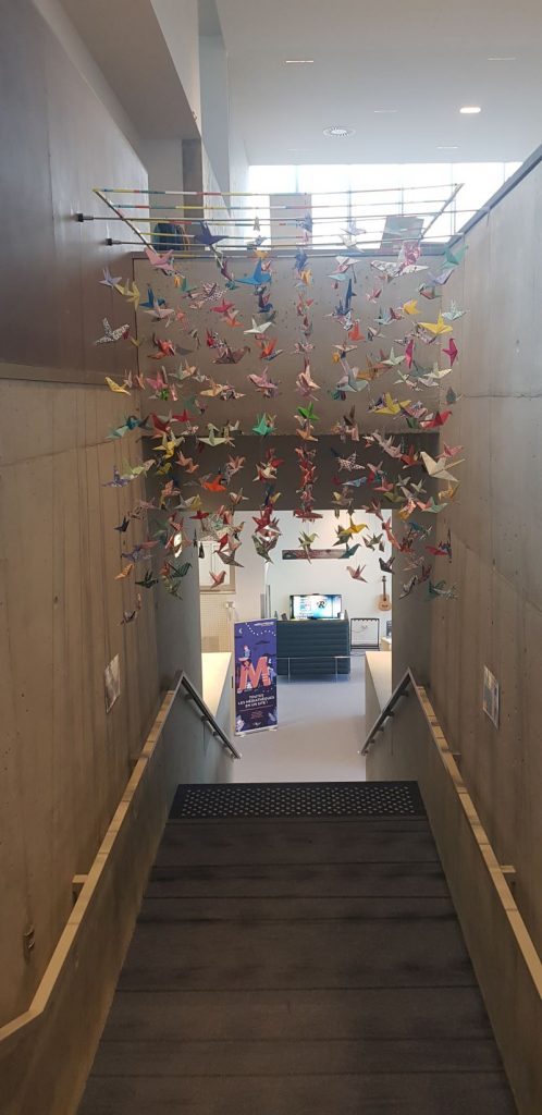 Photographies des grues en origami accrochées au-dessus de l'escalier