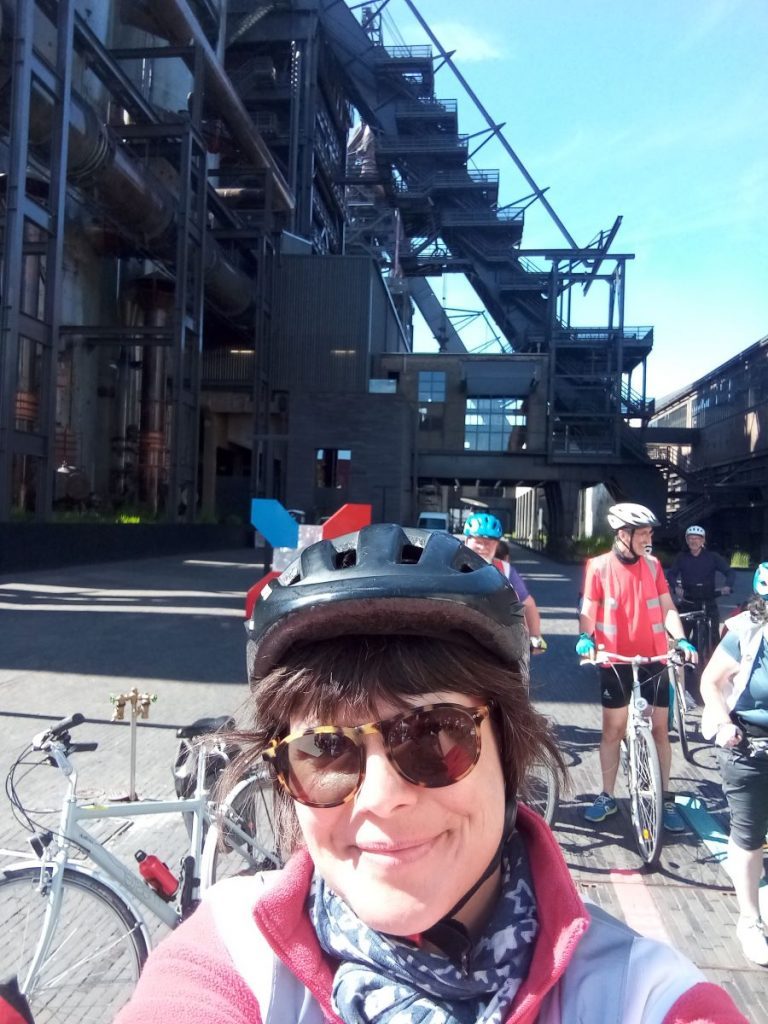 Portrait de Vanessa Derouen devant une ancienne usine sidérurgique