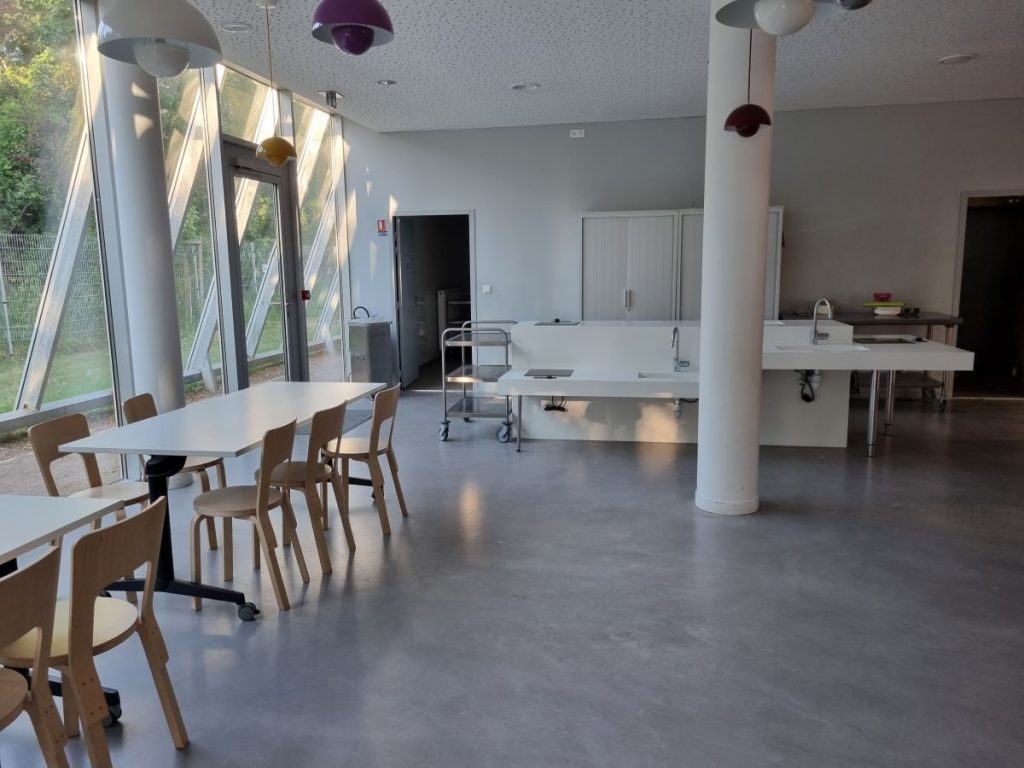 Photographie des tables et des plaques de cuisson et lavabos de la cuisine pédagogique