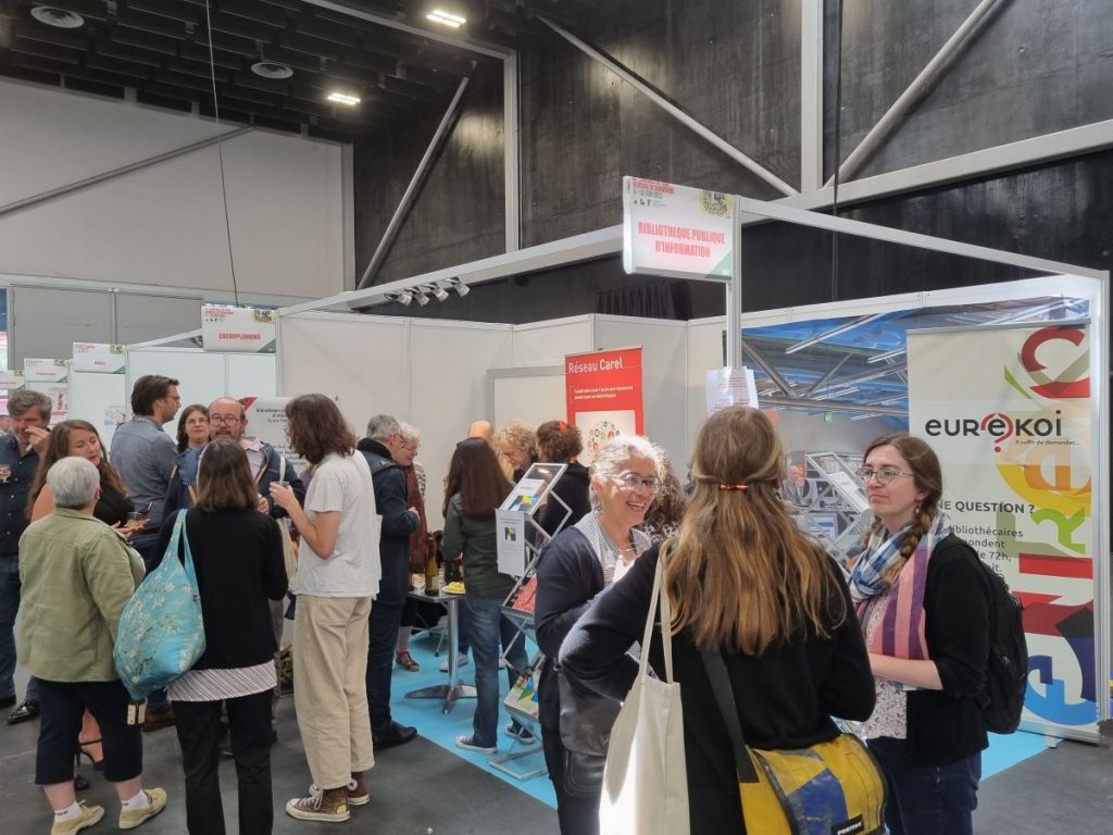 Photo du stand de la Bpi au congrès ABF 2023 avec des bibliothécaires qui discutent devant