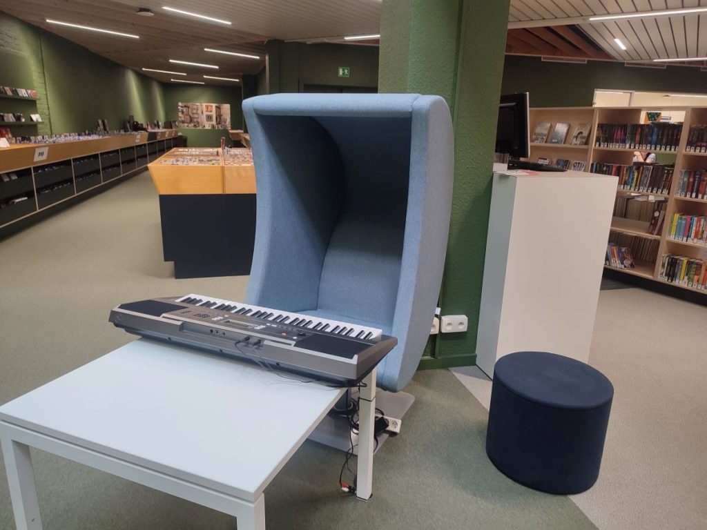 Photo du synthétiseur et du grand fauteuil bleu à la médiathèque centrale de Courtrai