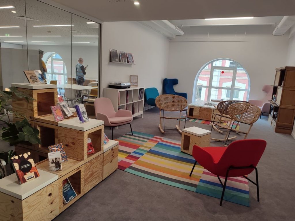 Photo du salon de musique de la BU de Sciences Po Lille avec des fauteuils et une platine vinyle avec des disques