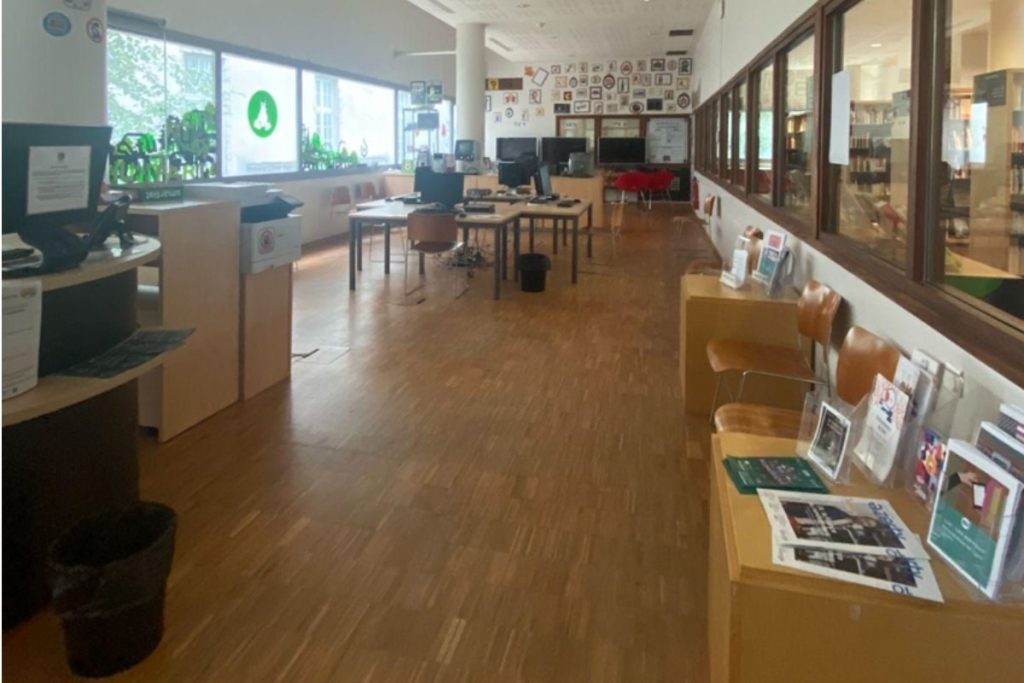 Une salle informatique avec des ordinateurs, des bureaux et des consoles de jeux