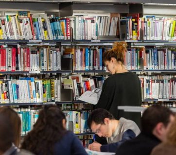 Lectrice consultant un ouvrage dans les rayonnages de la BPi