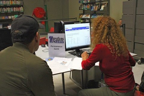 Photographie d'une permanence santé à la Bpi : une médiatrice et un usager face à l'écran