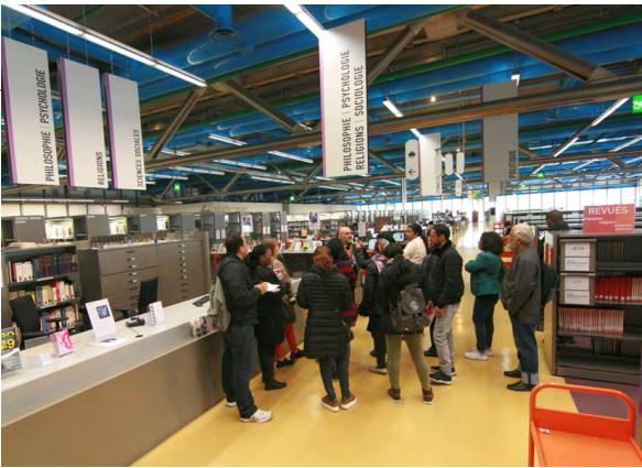 Photographie d'un groupe qui suit une visite guidée de la Bpi conduite pa un collègue